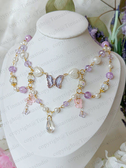 Close-up of gold-plated lavender butterfly necklace with crystal beads