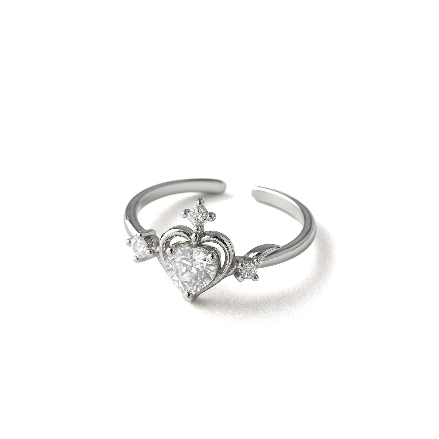 Dainty heart-shaped crystal ring worn on hand with sparkling nail art