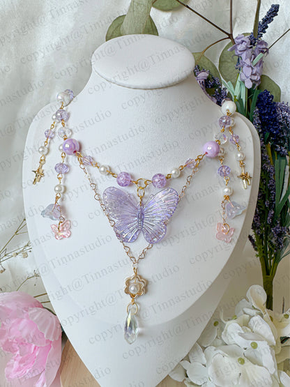 Purple version of the fairycore butterfly necklace on mannequin bust display.