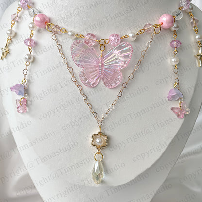 Close-up of pink fairycore necklace featuring iridescent butterfly and gold-plated chains.
