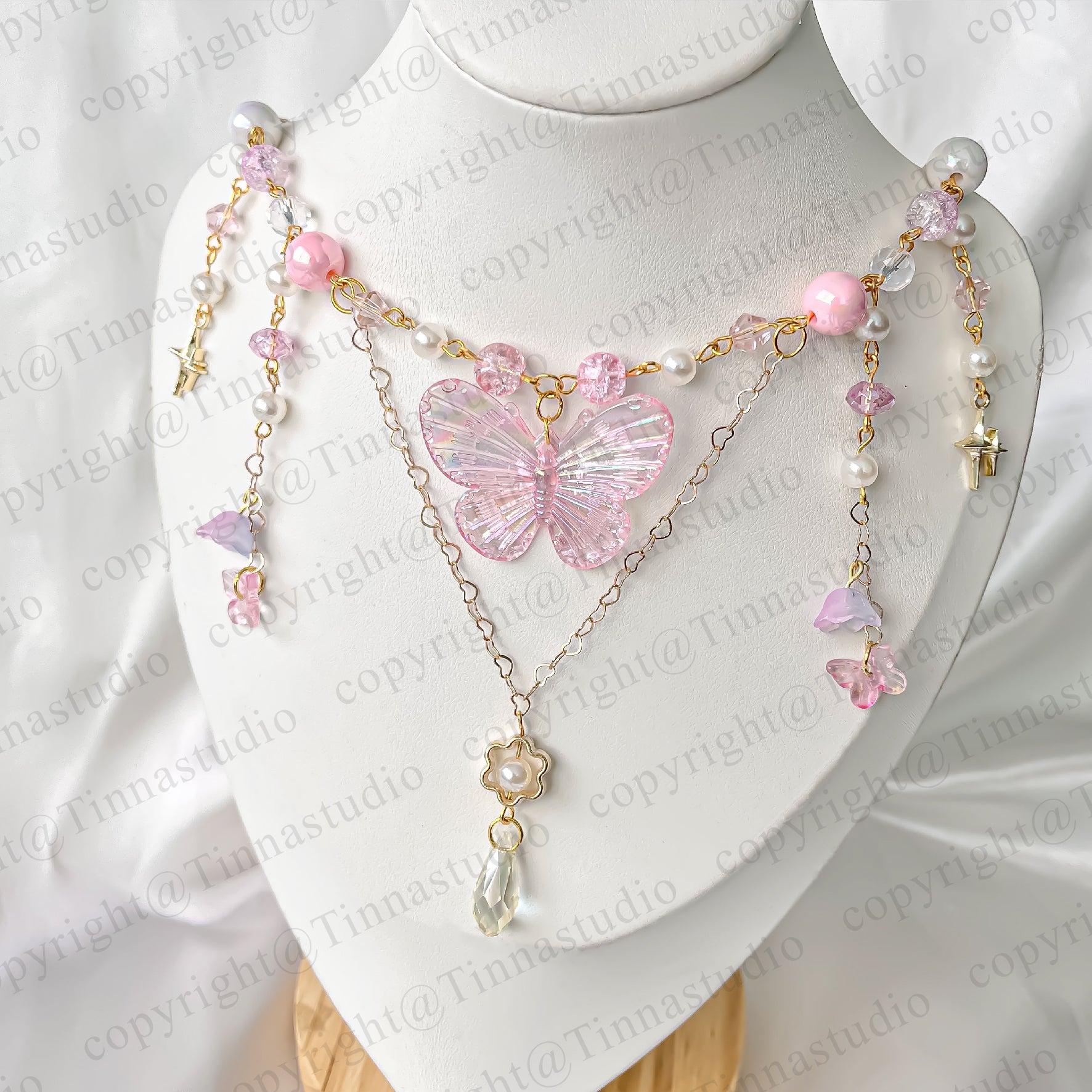 Handmade butterfly fairycore necklace in pastel pink with layered beads and crystal butterfly charm.