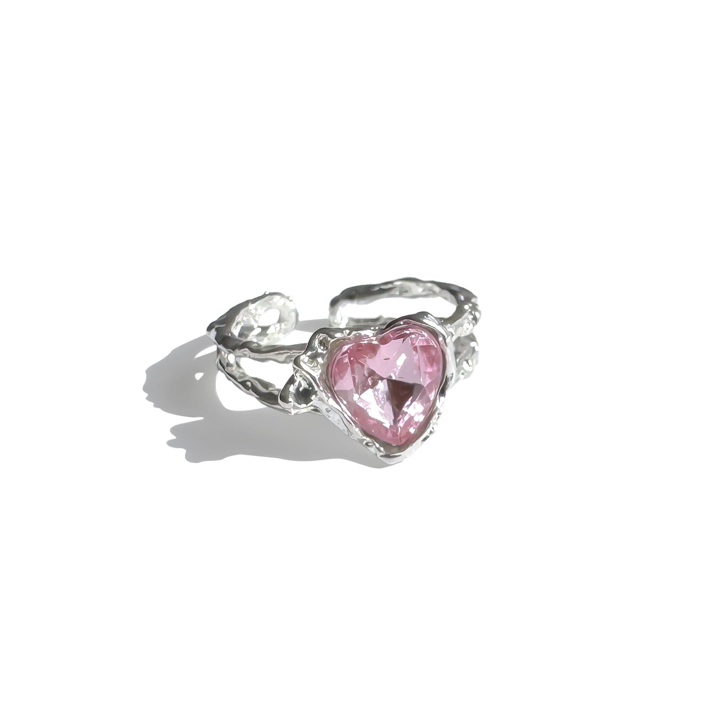 Single silver open-back ring with pink heart-shaped crystal under sunlight