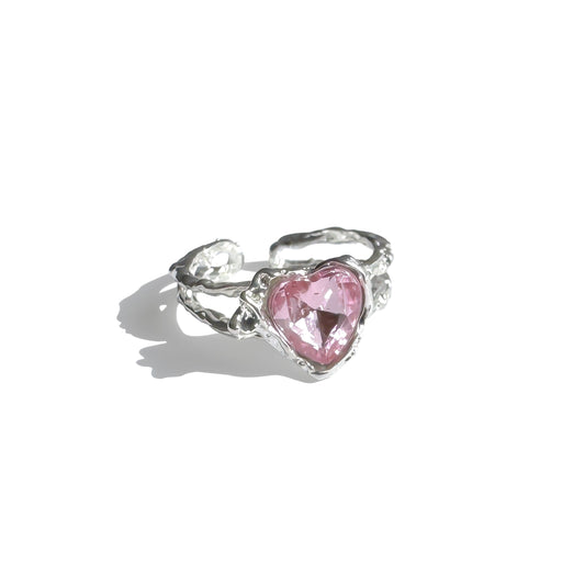 Single silver open-back ring with pink heart-shaped crystal under sunlight